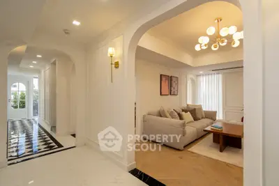 Elegant living room with modern chandelier and cozy seating area in a luxurious home.