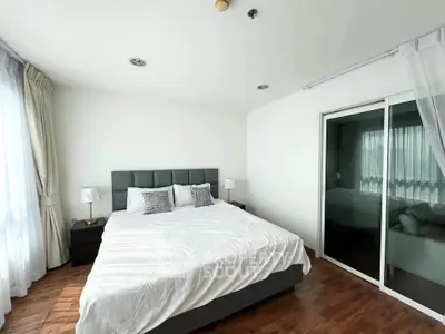 Spacious bedroom with modern decor and large windows for natural light