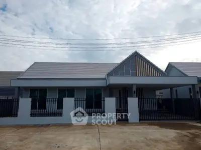 Modern single-story house with sleek design and spacious front yard, perfect for family living.