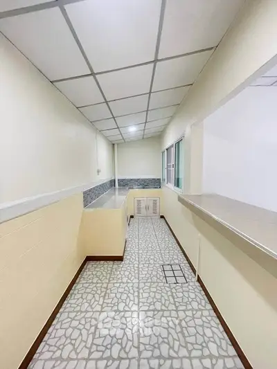 Spacious kitchen with open layout and modern design, featuring tiled flooring and ample counter space.