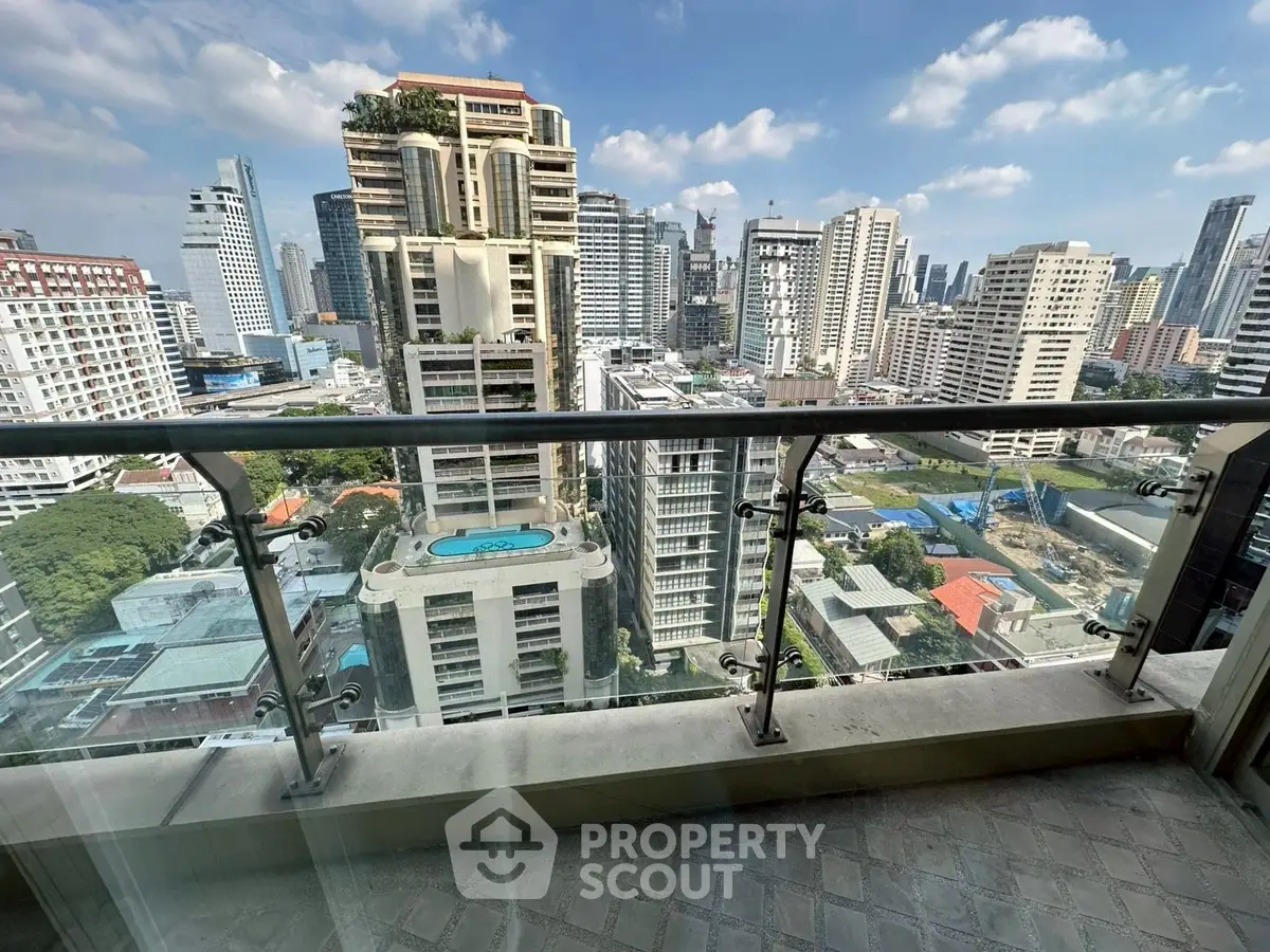 Stunning cityscape view from high-rise balcony with glass railing