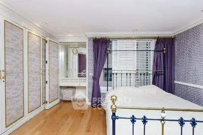 Elegant bedroom with classic decor, featuring a brass bed frame and built-in wardrobes.