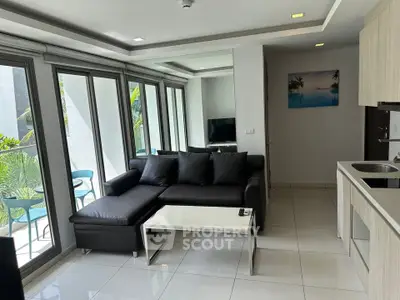 Modern living room with large windows and sleek black sofa in a stylish apartment.