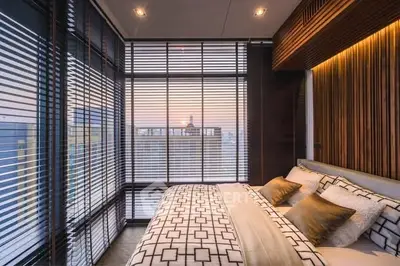 Luxurious bedroom with floor-to-ceiling windows offering stunning city views, modern decor, and elegant bedding.