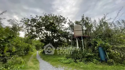 Scenic outdoor view with lush greenery and a water tank, perfect for nature lovers seeking tranquility.