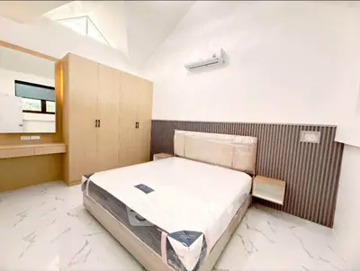 Modern bedroom with sleek design and natural light, featuring a stylish bed and built-in wardrobe.