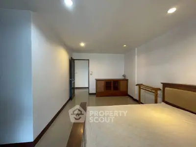 Spacious bedroom with minimalist decor and ample natural light