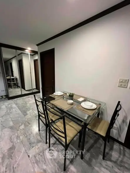Elegant dining area with glass table and modern decor in a stylish apartment.