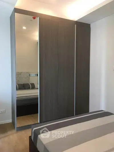 Modern bedroom with sleek wardrobe and stylish bed in a contemporary apartment.