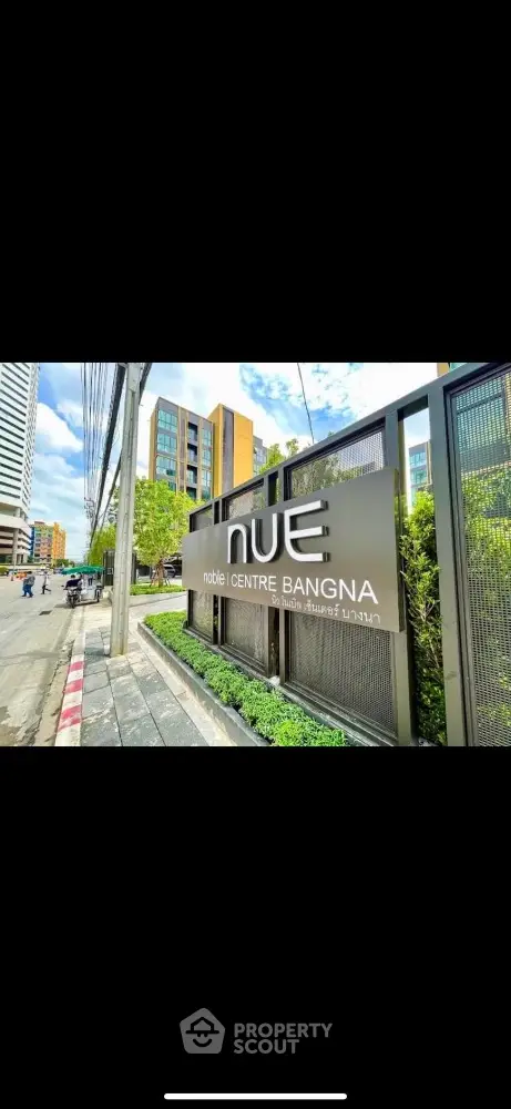 Modern urban building entrance with signage at Nue Centre Bangna, showcasing contemporary architecture.