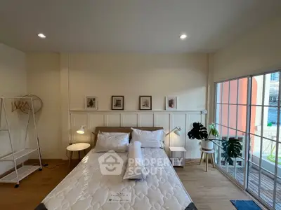 Spacious bedroom with modern decor and large windows for natural light.