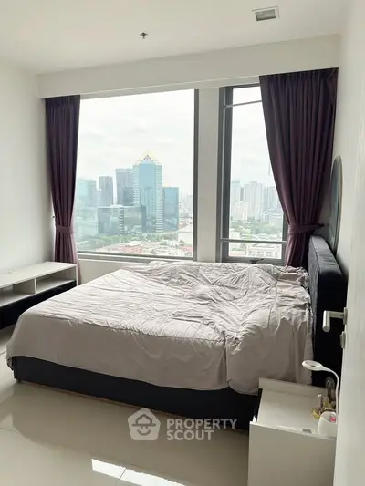 Luxurious bedroom with stunning city view and modern furnishings in high-rise apartment.