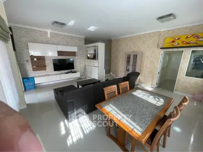 Spacious living room with modern decor and open layout, featuring a stylish entertainment center and dining area.