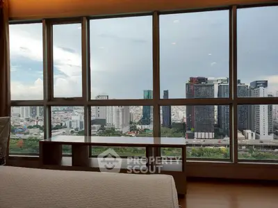 Stunning cityscape view from a modern high-rise apartment window, showcasing urban skyline and lush greenery.