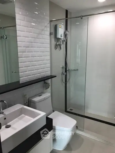 Modern bathroom with sleek design featuring glass shower and contemporary fixtures.