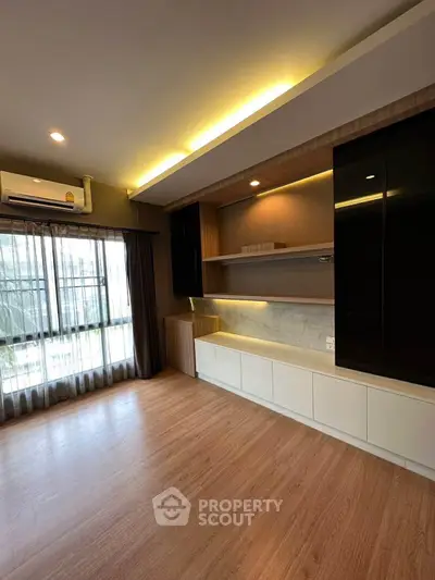 Spacious modern living room with built-in shelves and large window