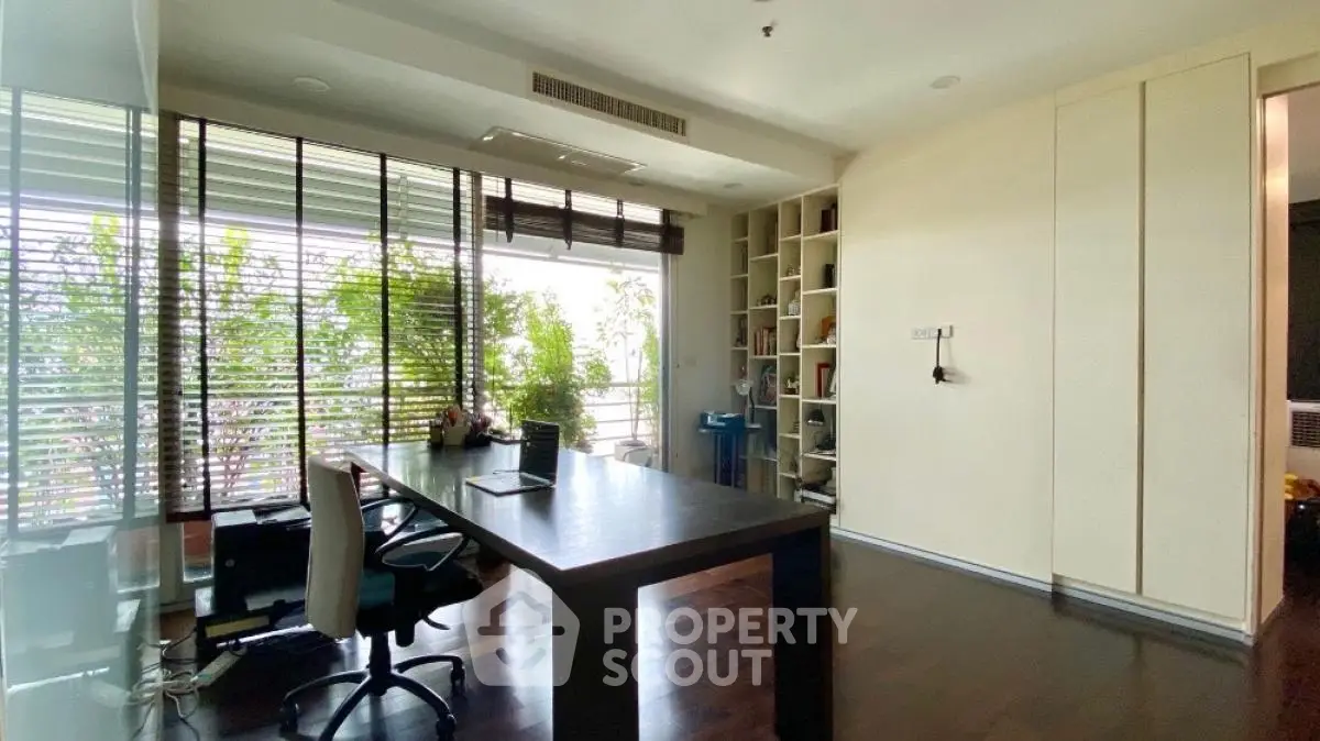 Spacious home office with large window and modern desk, ideal for productivity.