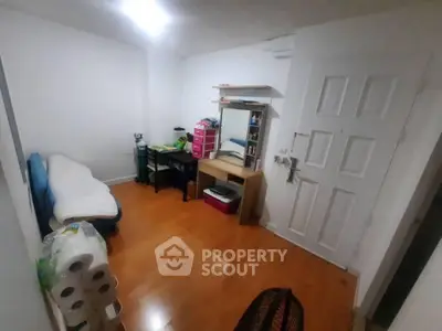 Cozy small room with wooden flooring, desk, and minimal furnishings, ideal for compact living.