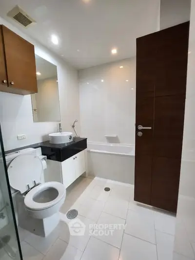 Modern bathroom with sleek fixtures and bathtub in a contemporary apartment.