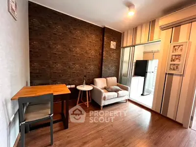 Cozy living room with modern decor and wooden flooring, featuring a small sofa and dining table.