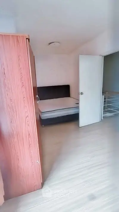 Cozy bedroom with wooden wardrobe and comfortable bed in a bright apartment.