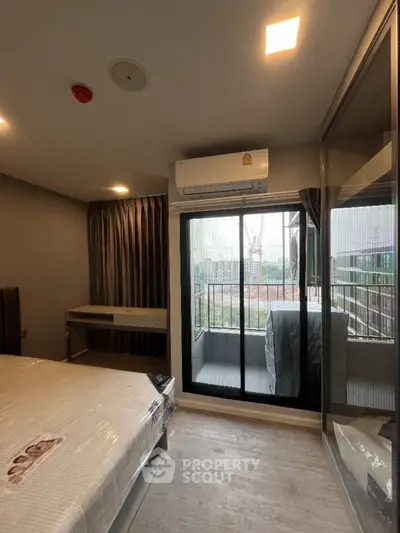 Modern bedroom with balcony access and air conditioning in urban apartment