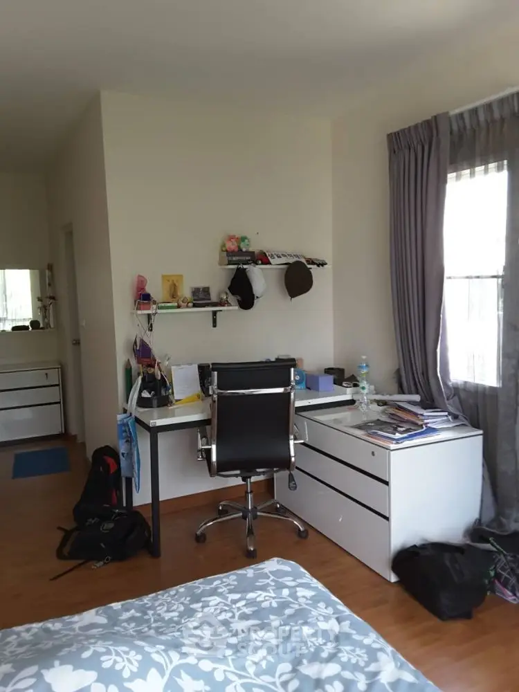 Modern study room with sleek desk and chair, ample natural light, and organized shelves.