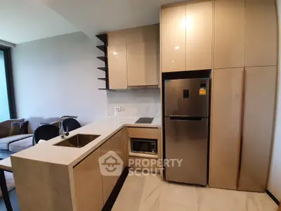 Modern kitchen with sleek cabinetry and stainless steel appliances in a stylish apartment.