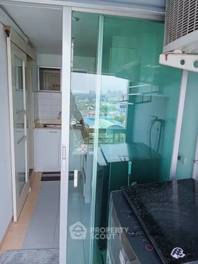 Compact balcony with washing machine and city view