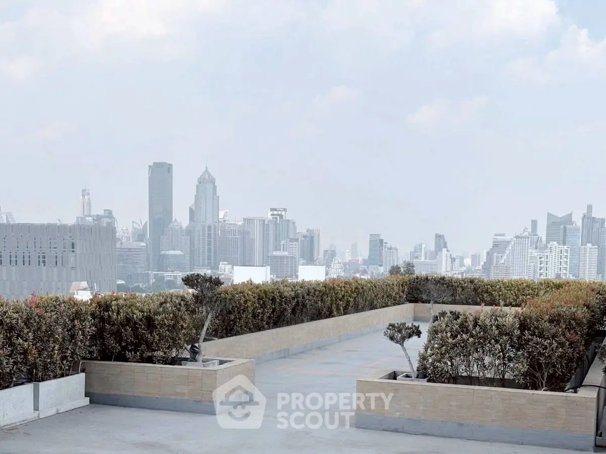 Stunning rooftop view of city skyline with lush greenery and open space.