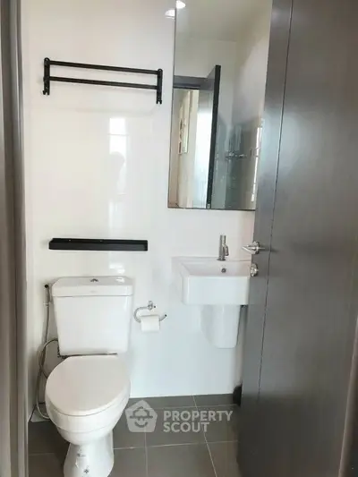 Modern bathroom with sleek fixtures and neutral tones, featuring a compact design for efficient space use.