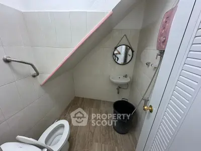 Compact bathroom with sloped ceiling and modern fixtures, ideal for small spaces.
