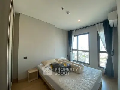 Modern bedroom with large window and city view, featuring a comfortable bed and minimalist decor.