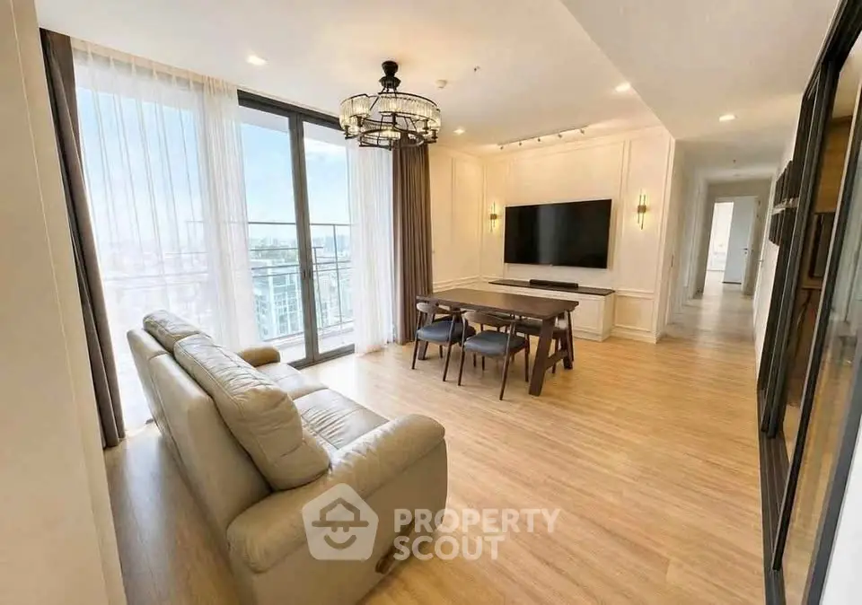 Spacious modern living room with large windows and elegant decor in a high-rise apartment.