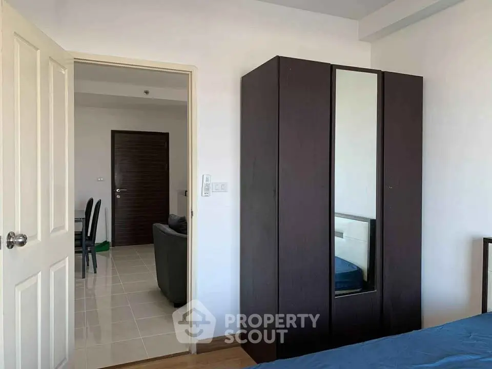 Spacious bedroom with modern wardrobe and view into living area