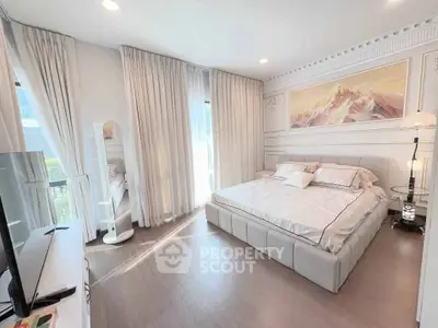 Luxurious bedroom with elegant decor and ample natural light, featuring a plush bed and stylish furnishings.