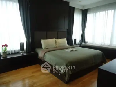Luxurious bedroom with elegant dark wood accents and large windows