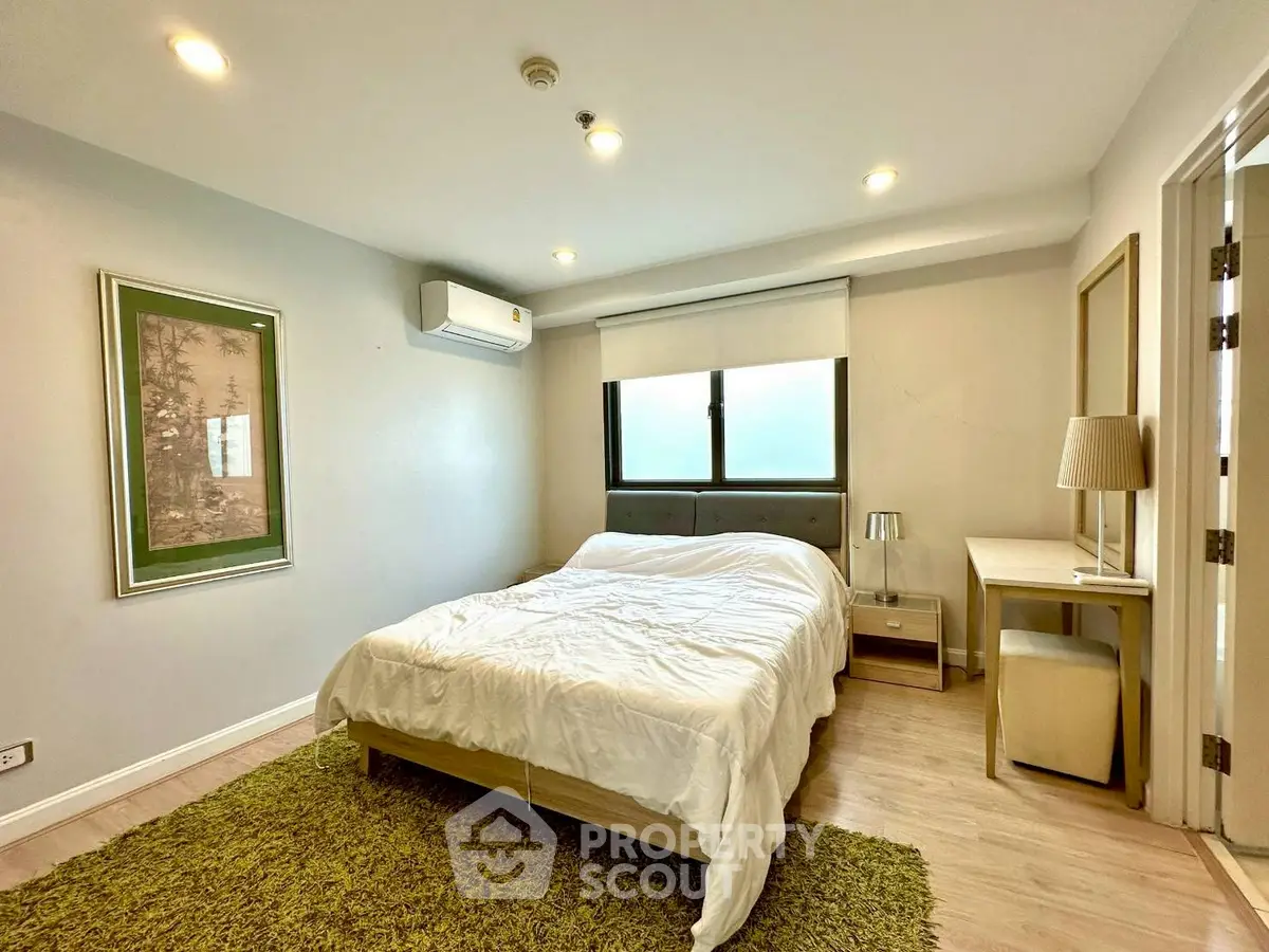 Spacious bedroom with modern decor and natural light