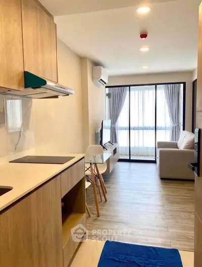 Modern open-layout kitchen and living room with natural light and stylish decor.