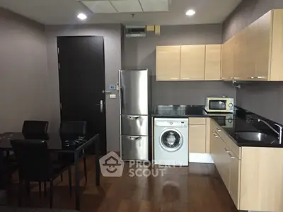 Modern kitchen with wooden cabinets, stainless steel appliances, and dining area in a cozy apartment.
