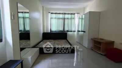 Spacious and well-lit bedroom with glossy tiled flooring, modern furnishings, and a serene ambiance, perfect for relaxation and comfort.