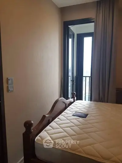 Cozy bedroom with balcony access and elegant wooden bed frame, perfect for urban living.