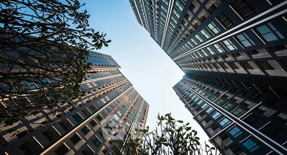 Stunning upward view of modern high-rise buildings with clear sky backdrop.