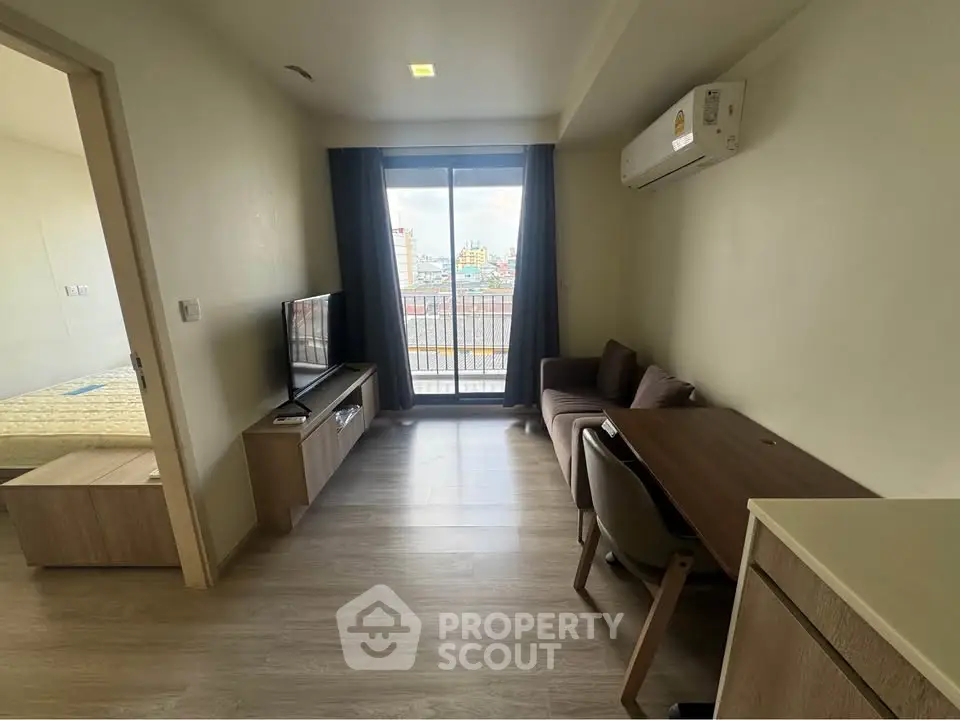 Modern living room with balcony view, featuring sleek furniture and natural light.