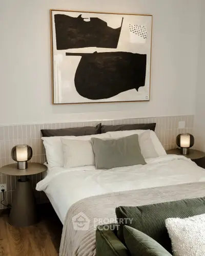 Stylish bedroom with modern decor and abstract art, featuring cozy bedding and ambient lighting.