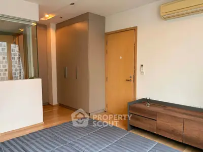 Modern bedroom with sleek design, featuring built-in wardrobe and air conditioning unit.