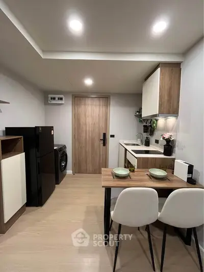 Modern kitchen with sleek design, featuring compact dining area and integrated appliances, perfect for urban living.