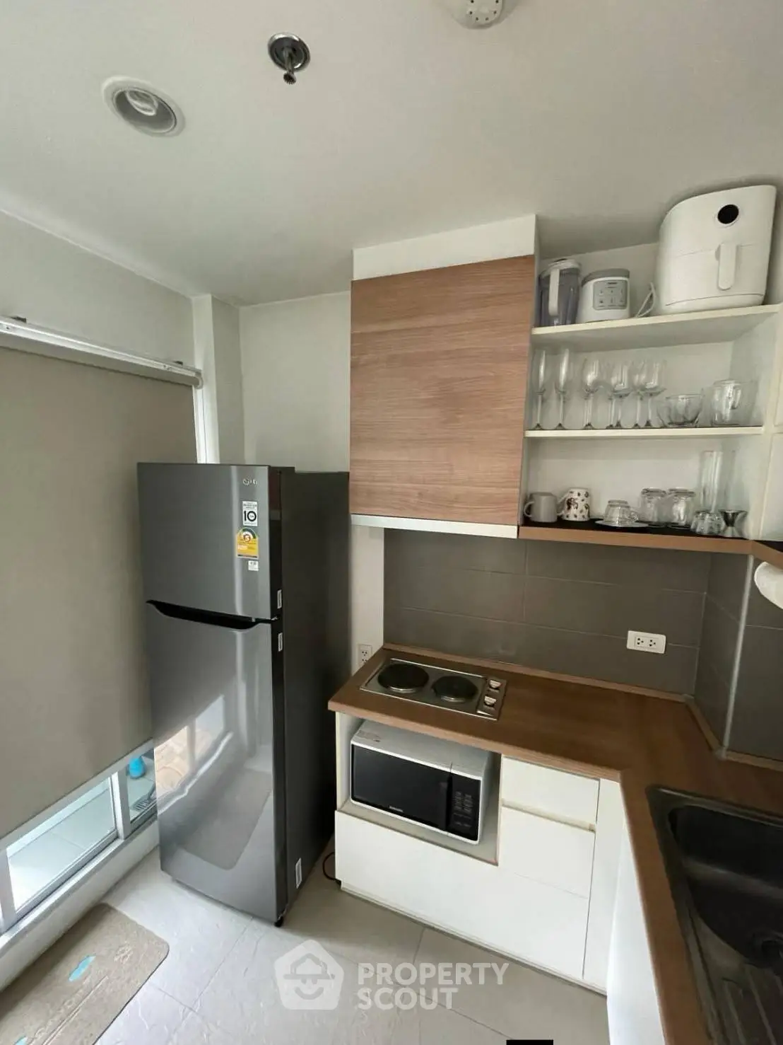 Modern kitchen with sleek appliances and wooden cabinetry in a compact layout.
