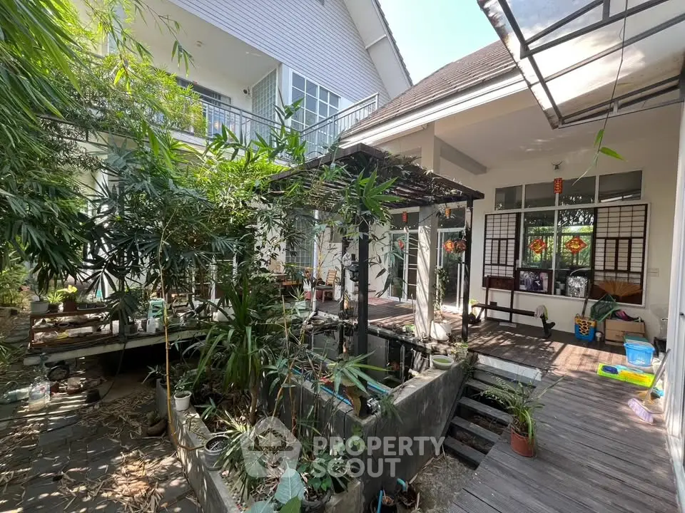 Charming garden view of a modern home with lush greenery and spacious patio, perfect for outdoor relaxation.