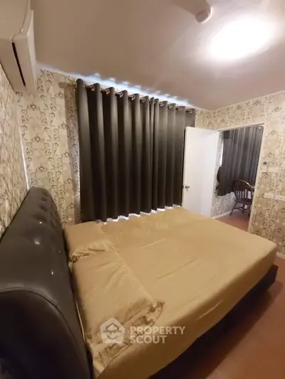 Cozy bedroom with elegant wallpaper and plush bedding, featuring a comfortable atmosphere for relaxation.